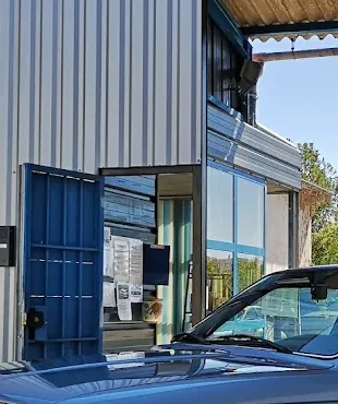 Porte d’atelier ouverte de LNB Carrosserie donnant sur l’espace de travail.